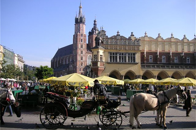 Een groot plein in Kraków, Polen, omzoomd met cafés en bars waar bezoekers nationale bieren kunnen proeven.
