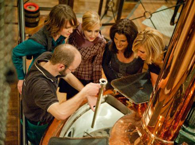 Vrouwelijke bierliefhebbers volgen aandachtig de brouwmeester van het tot brouwhuis omgebouwde station in Leipzig, Oost-Duitsland.